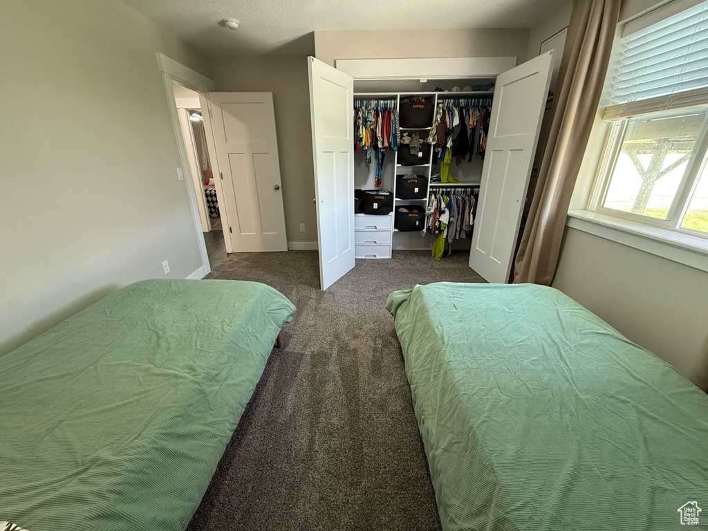 Carpeted bedroom featuring a closet and baseboards