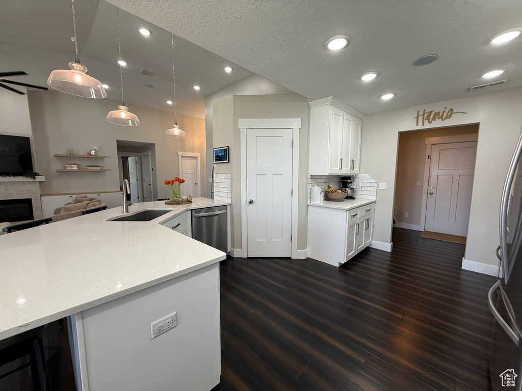 Kitchen with stainless steel appliances, a sink, dark wood-style flooring, white cabinets, and recessed lighting