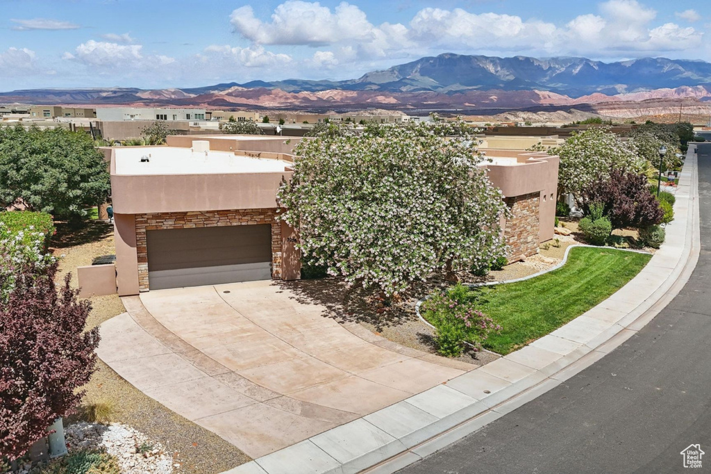 Pueblo revival-style home featuring a mountain view, stucco siding, and stone siding