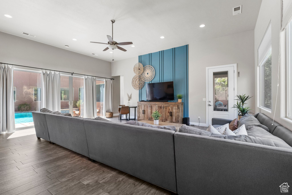 Living area with a ceiling fan, recessed lighting, dark wood-type flooring, and baseboards