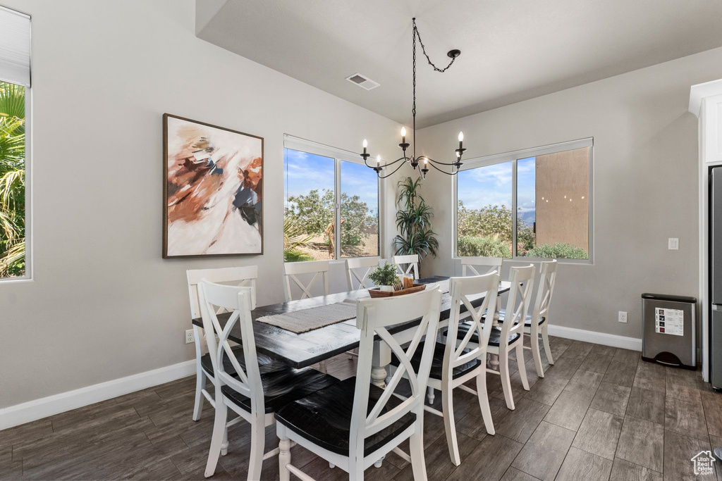 Dining area featuring a chandelier, wood finished floors, and baseboards
