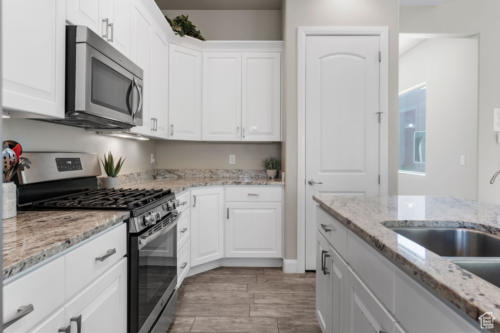 Kitchen with stainless steel appliances, white cabinets, and a sink