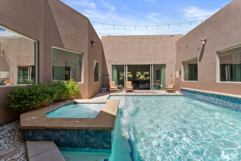 Outdoor pool with an in-ground hot tub and a patio area