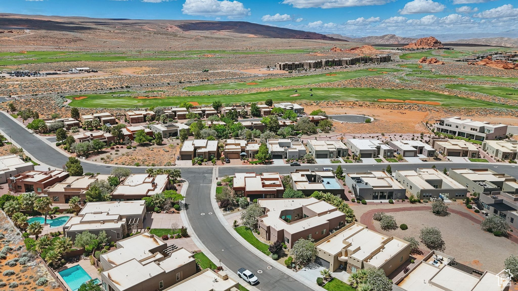 Aerial view of residential area featuring a mountain backdrop and a golf course