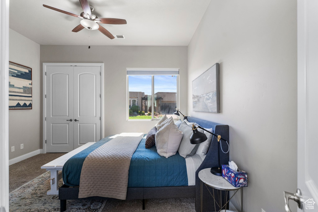 Bedroom with carpet flooring, baseboards, ceiling fan, and a closet