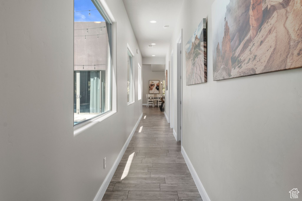 Corridor with baseboards, wood finished floors, and recessed lighting