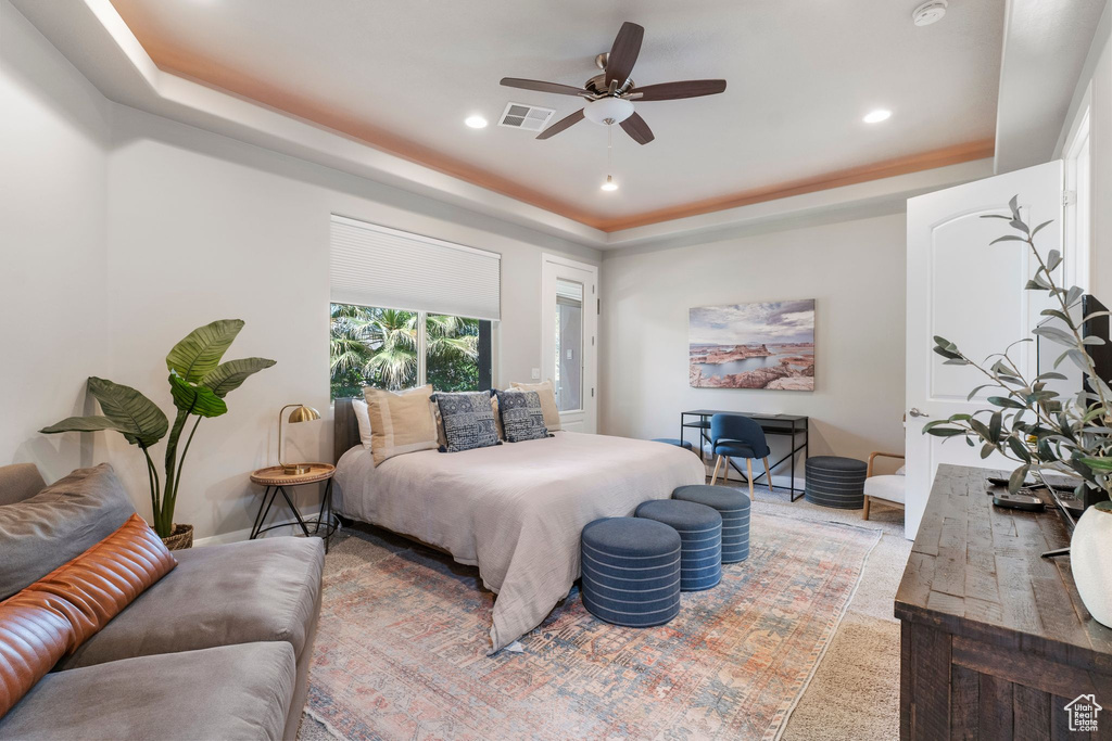 Bedroom with a tray ceiling, recessed lighting, and a ceiling fan