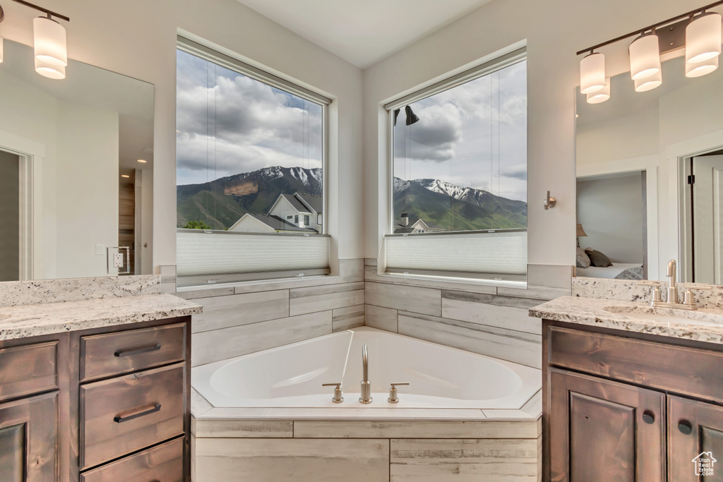 Full bath with vanity, a mountain view, a garden tub, and ensuite bath