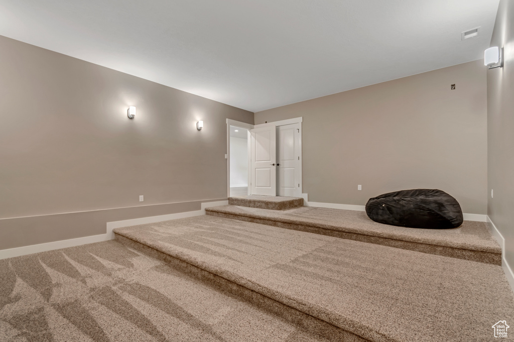 Carpeted spare room featuring baseboards