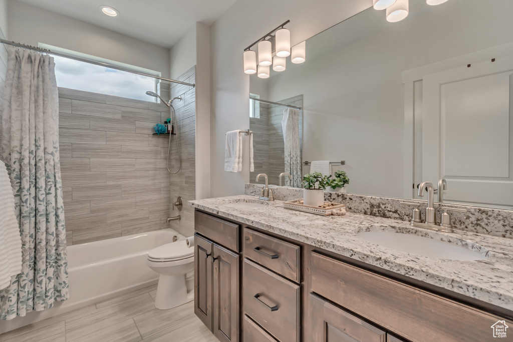 Full bath with shower / bathtub combination with curtain, toilet, double vanity, and recessed lighting