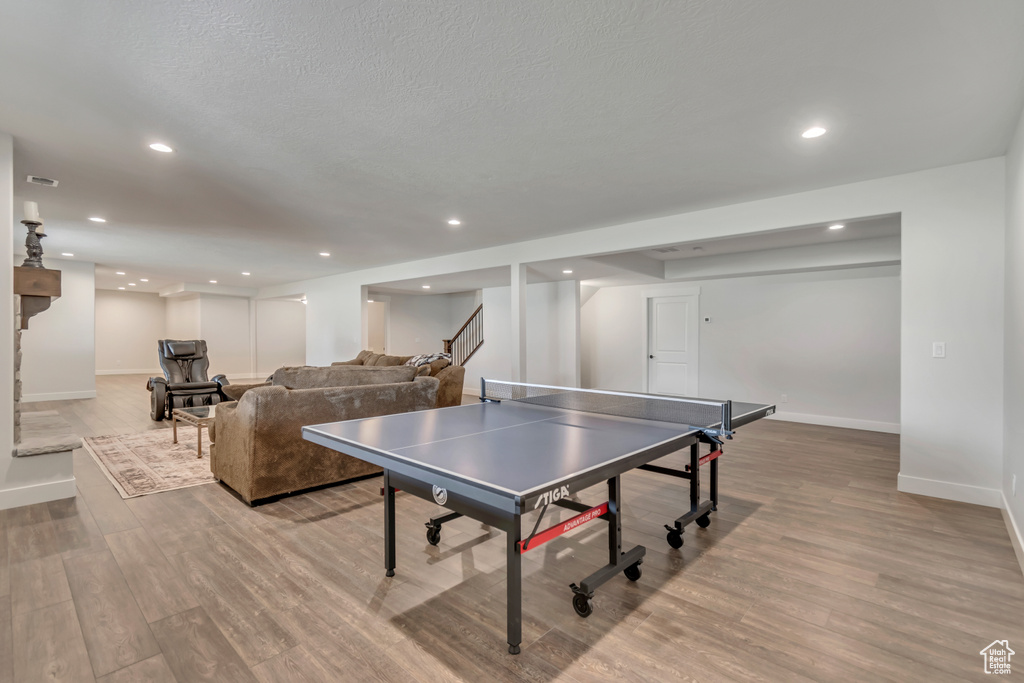 Game room with baseboards, wood finished floors, and recessed lighting