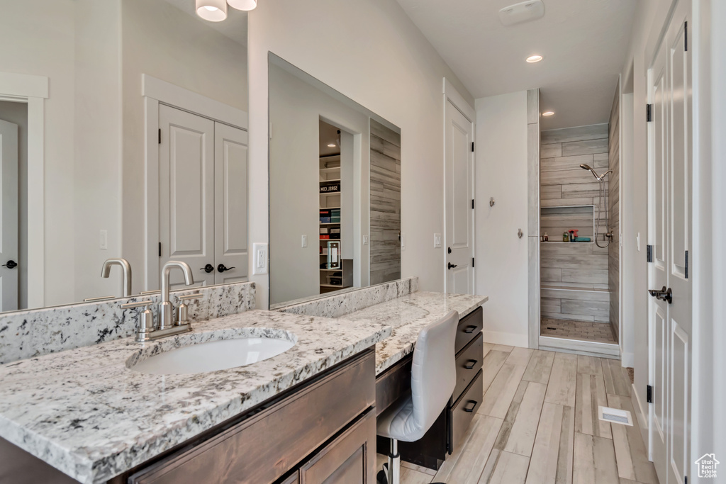 Full bathroom with a shower stall, recessed lighting, a closet, vanity, and baseboards