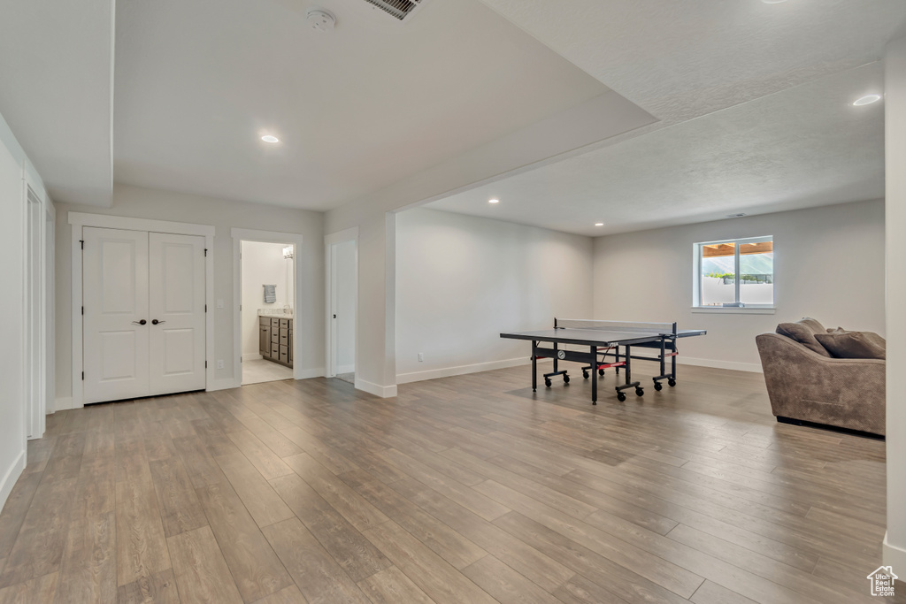 Recreation room with baseboards, light wood-type flooring, and recessed lighting