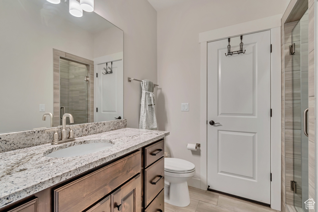 Full bathroom featuring a shower stall, vanity, and toilet