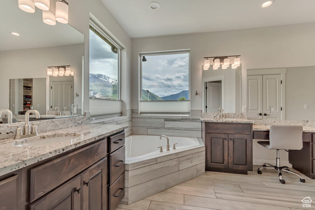 Full bath featuring a garden tub, recessed lighting, a closet, and two vanities