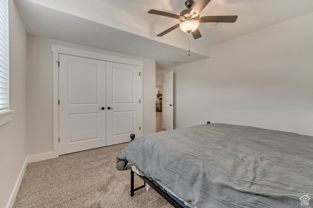 Bedroom featuring carpet floors, baseboards, a ceiling fan, and a closet