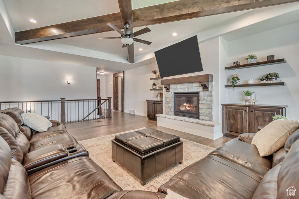 Living room featuring beamed ceiling, wood finished floors, a ceiling fan, recessed lighting, and a fireplace