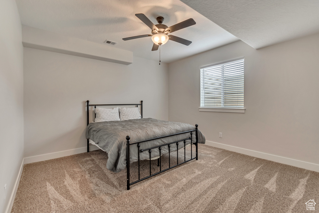 Carpeted bedroom featuring baseboards and ceiling fan