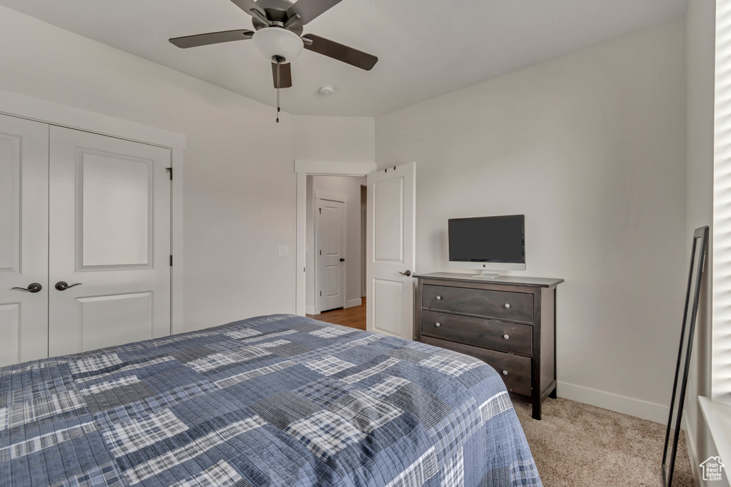 Bedroom with baseboards, carpet flooring, a closet, and a ceiling fan