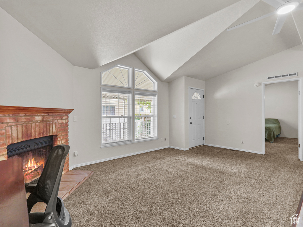 Unfurnished living room with carpet flooring, vaulted ceiling, baseboards, a brick fireplace, and ceiling fan