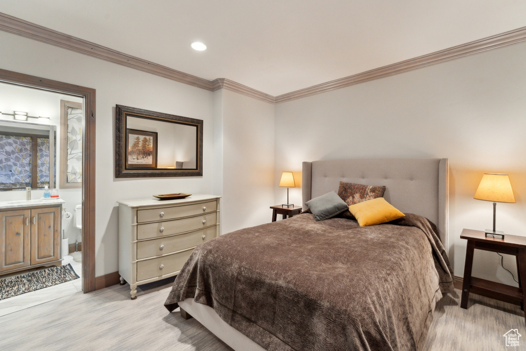 Bedroom featuring ornamental molding, baseboards, recessed lighting, light wood-style floors, and ensuite bath