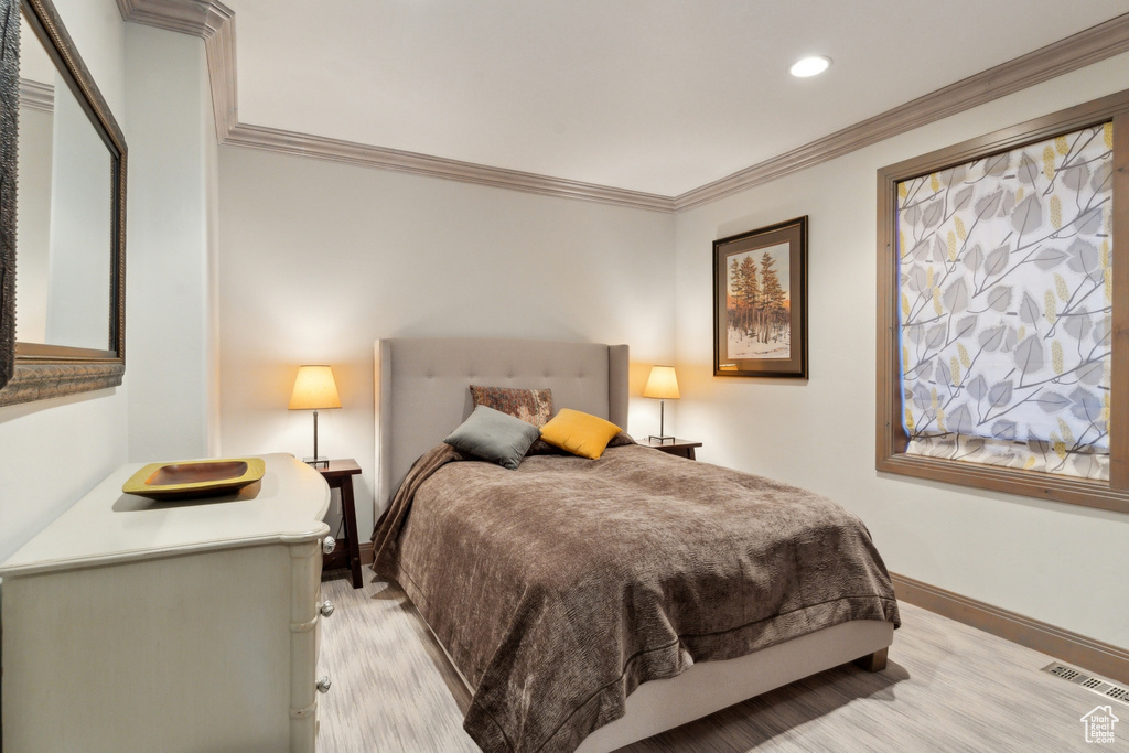 Bedroom featuring light wood-style floors, baseboards, recessed lighting, and crown molding