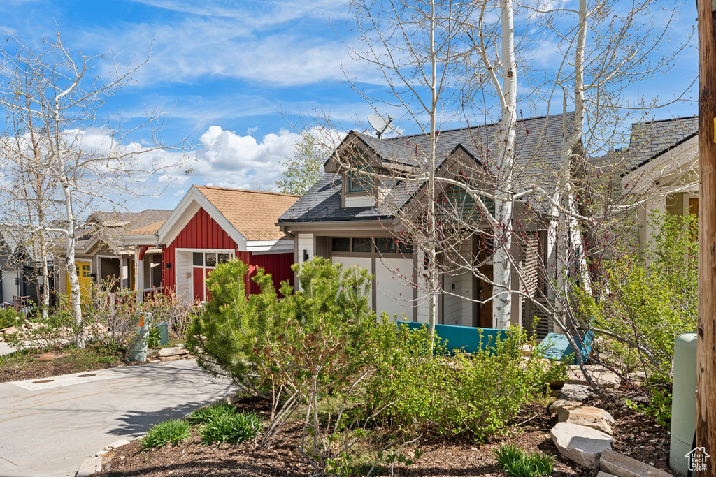 View of front of house with a shingled roof and board and batten siding