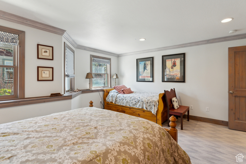 Bedroom with crown molding, baseboards, recessed lighting, and light wood finished floors