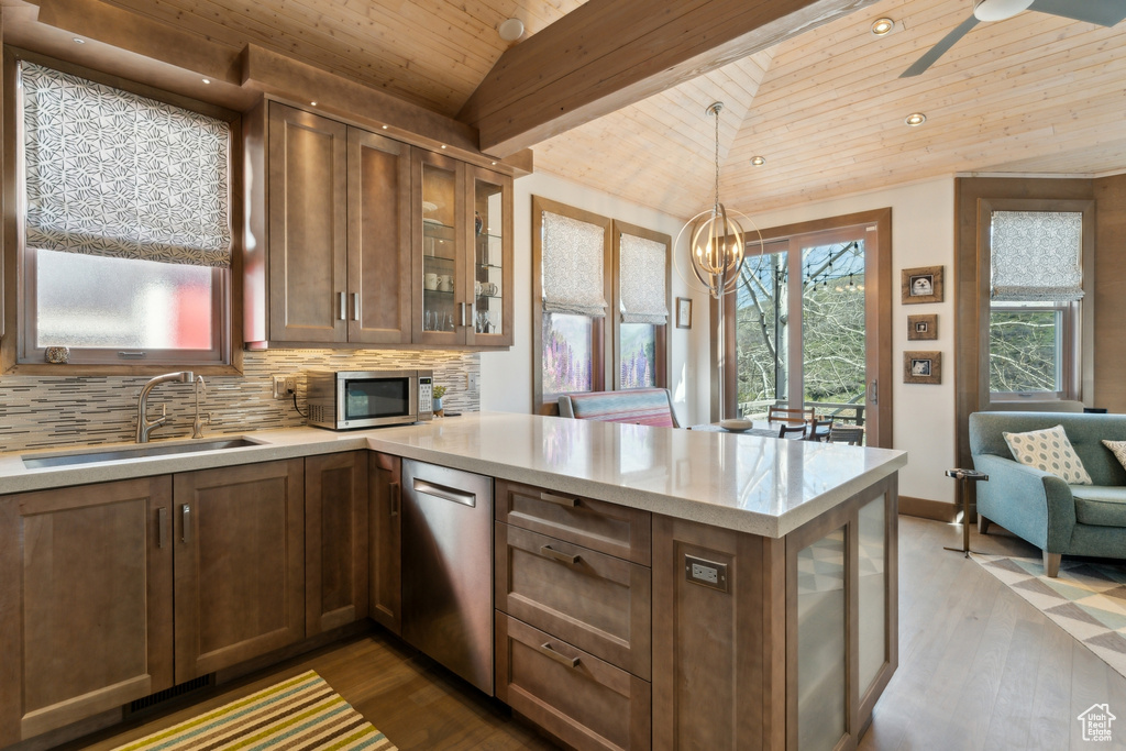 Kitchen with vaulted ceiling, a sink, stainless steel appliances, a peninsula, and wooden ceiling