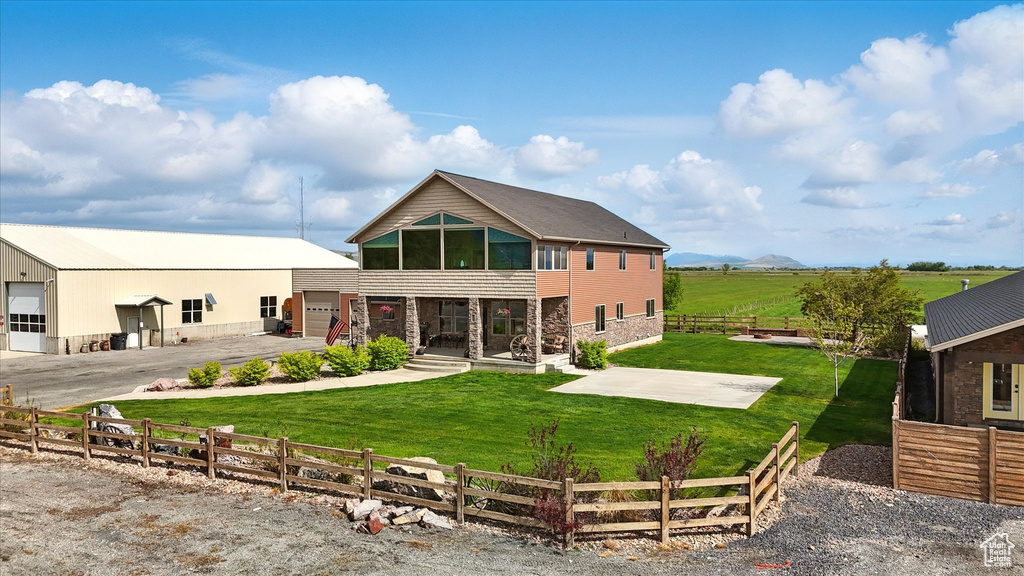 Rear view of property with stone siding and a garage