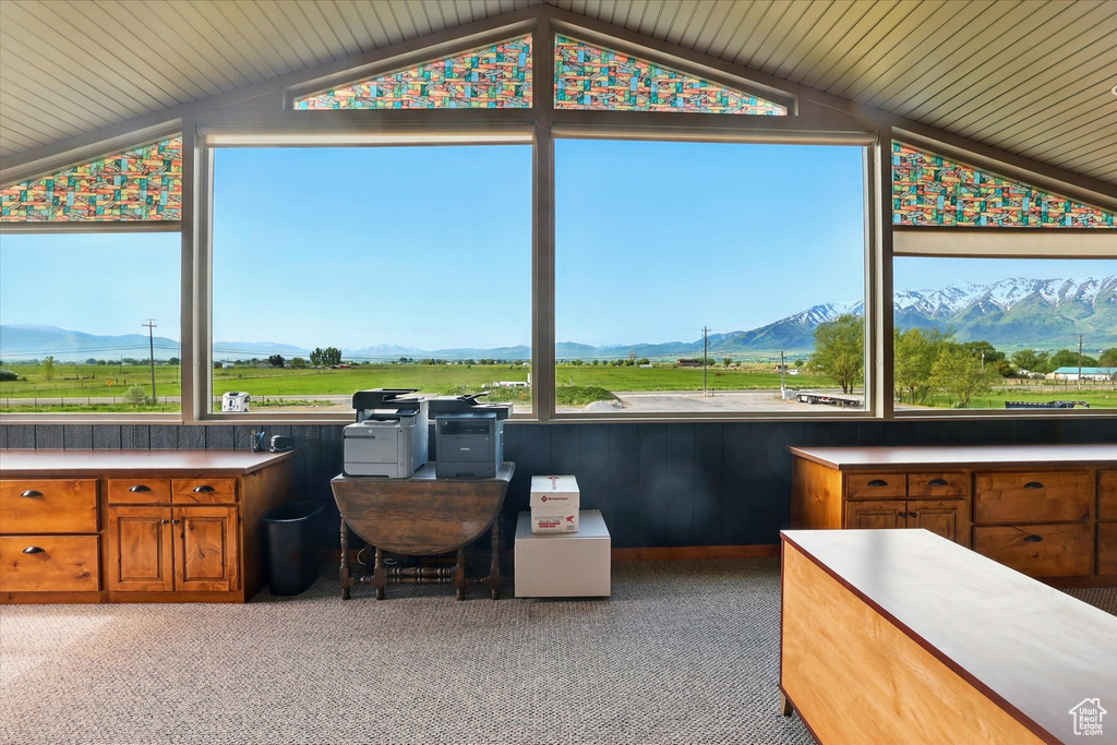 Sunroom featuring a mountain view, lofted ceiling, carpet, and plenty of natural light