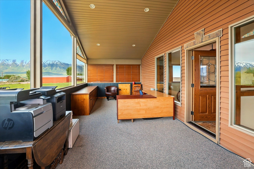 Sunroom / solarium featuring carpet floors, vaulted ceiling, a mountain view, wooden walls, and recessed lighting