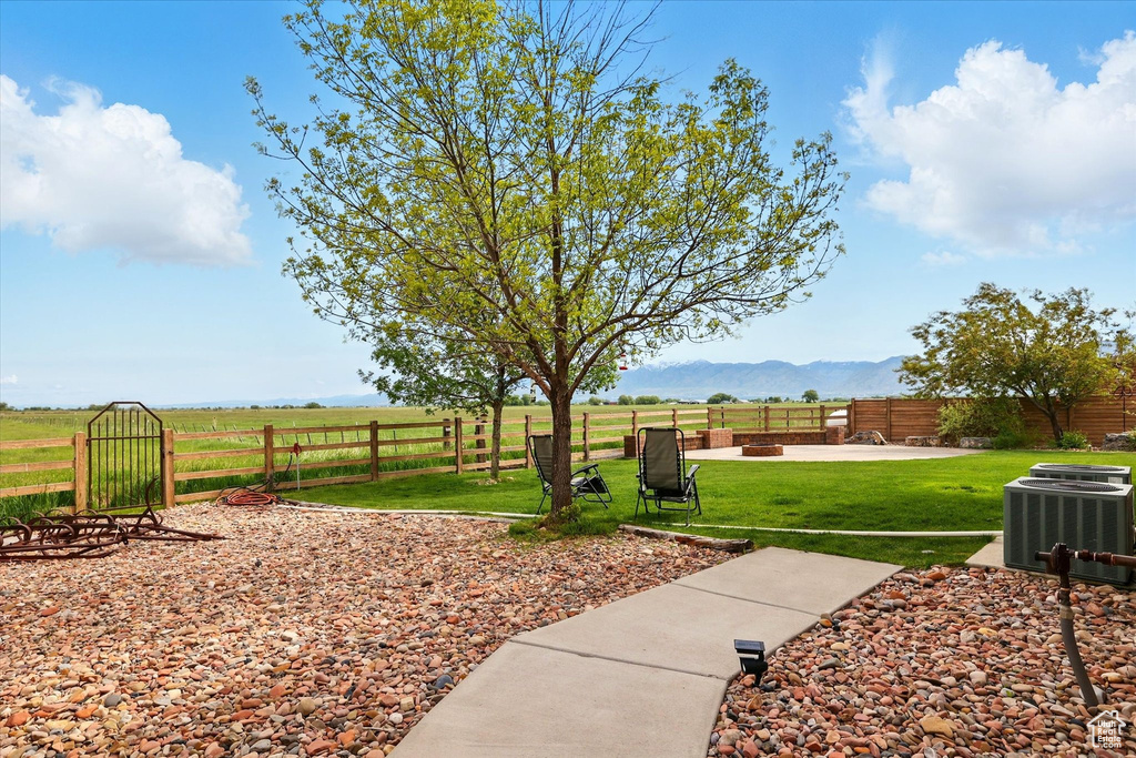 View of yard featuring central AC, a mountain view, and a view of rural / pastoral area