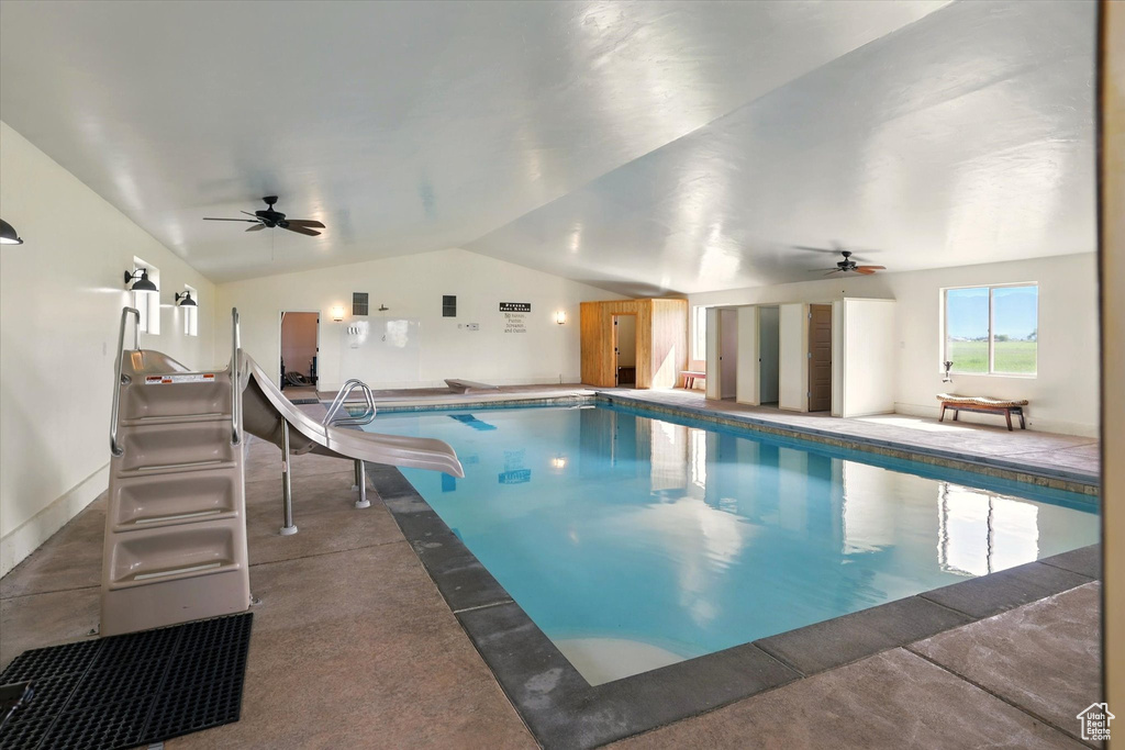 Indoor pool with ceiling fan and a water slide