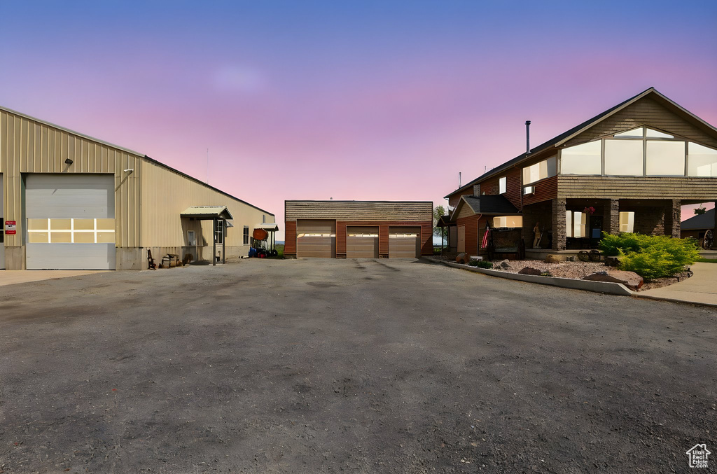 View of front of house featuring a garage and an outbuilding
