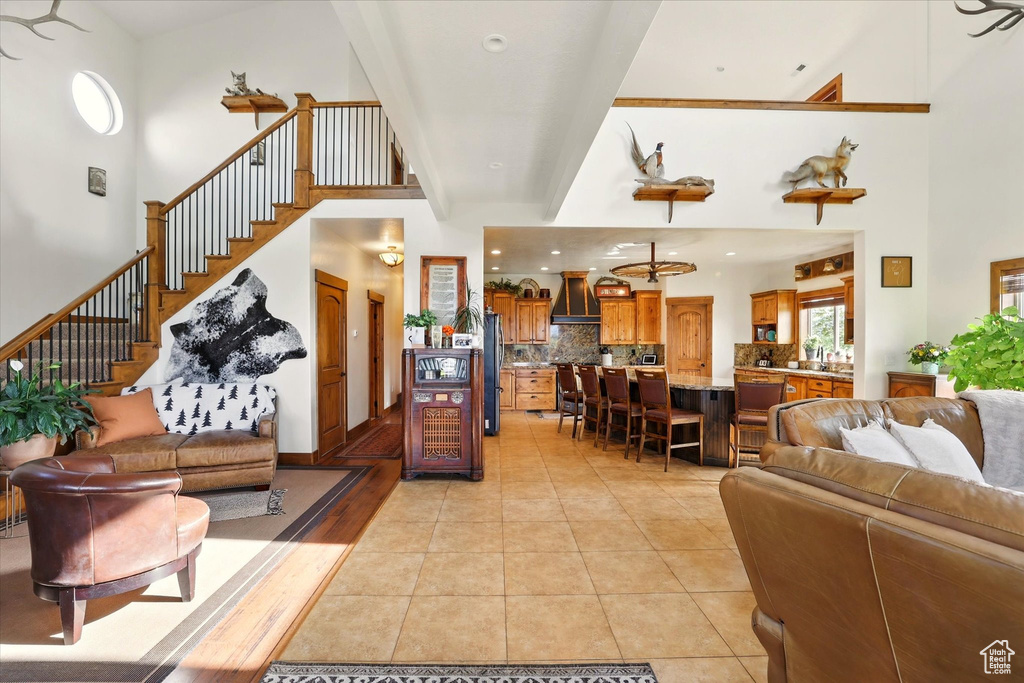 Living room with a towering ceiling, stairs, and light tile patterned floors