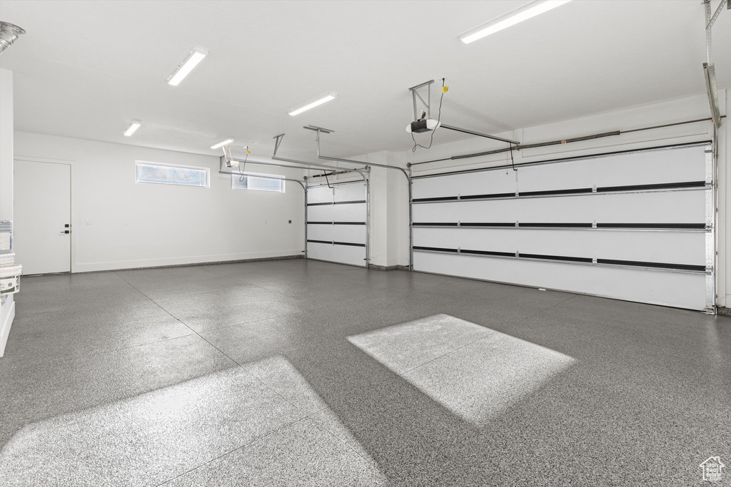 Garage with a garage door opener and baseboards