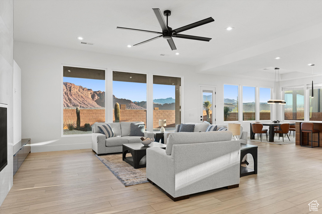 Living room with light wood-style flooring, a ceiling fan, recessed lighting, and a mountain view
