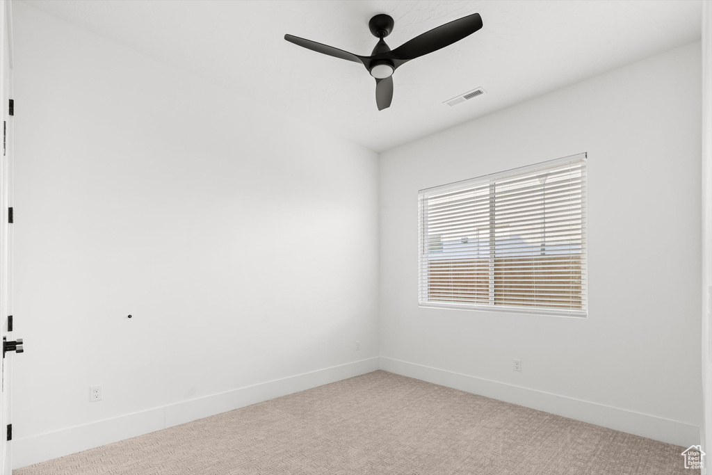 Empty room with carpet, a ceiling fan, and baseboards