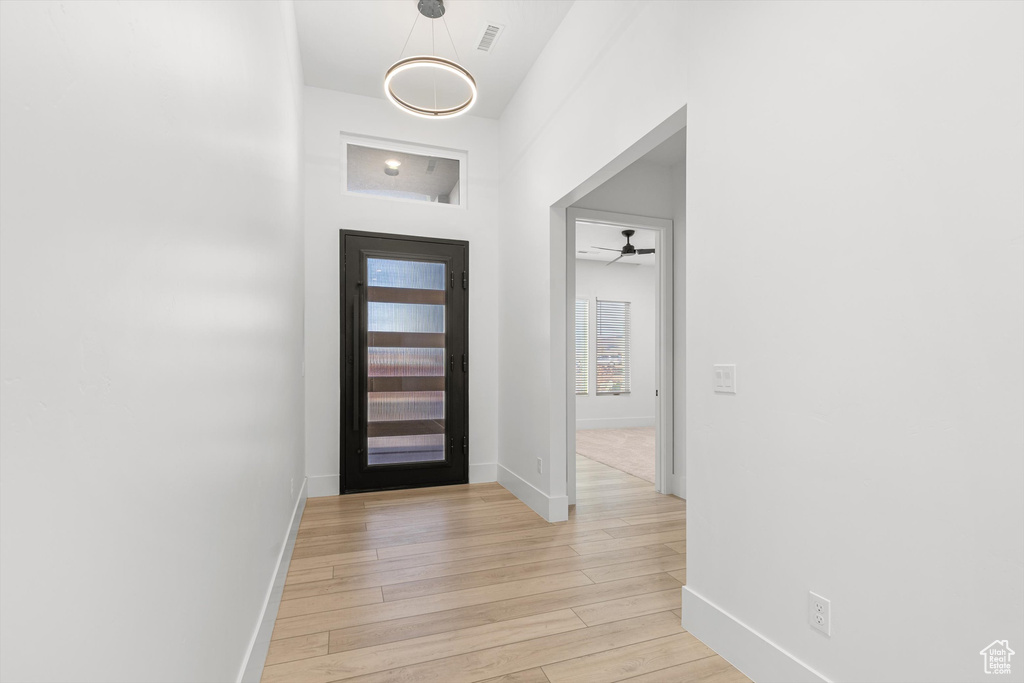 Foyer featuring baseboards, light wood-style flooring, and a ceiling fan