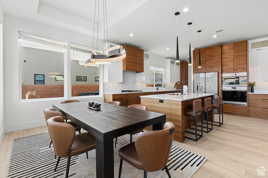Dining room featuring light wood-type flooring, recessed lighting, and baseboards