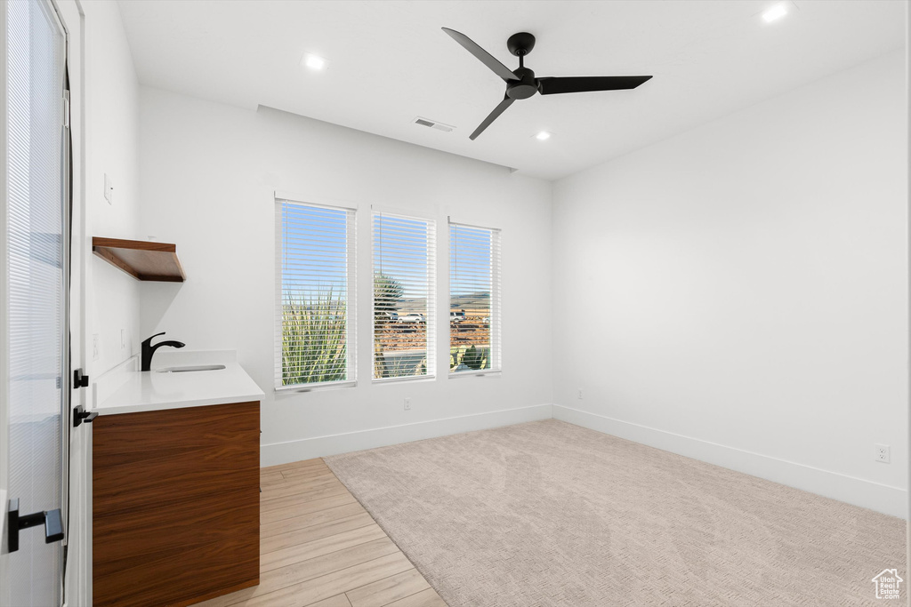 Bathroom featuring a ceiling fan, a sink, recessed lighting, baseboards, and wood finished floors