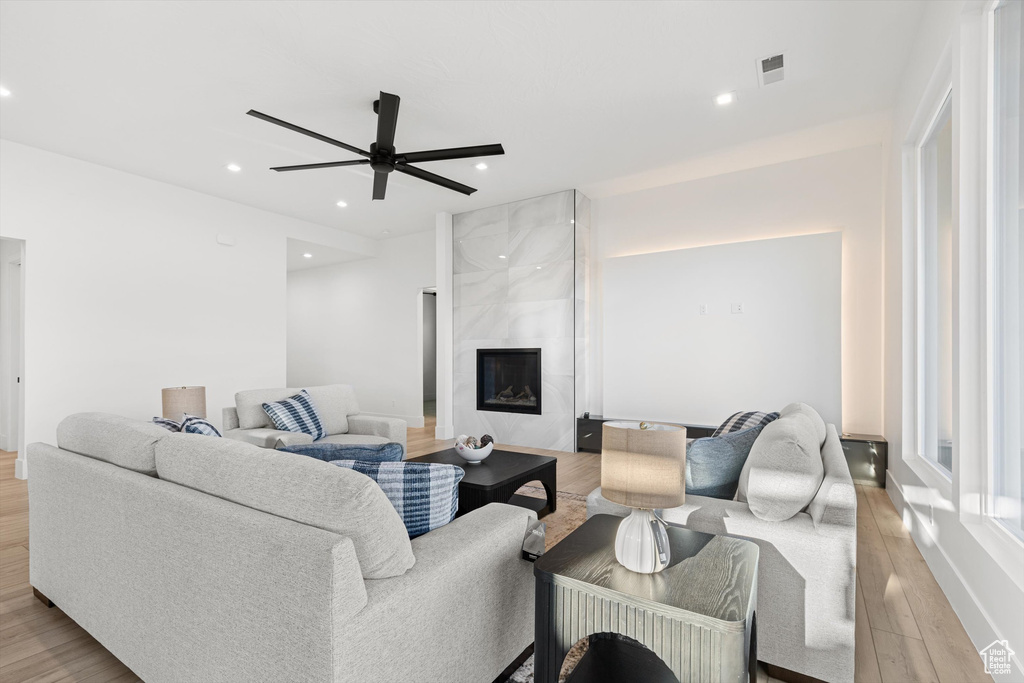 Living area with light wood-style flooring, recessed lighting, a ceiling fan, and a high end fireplace