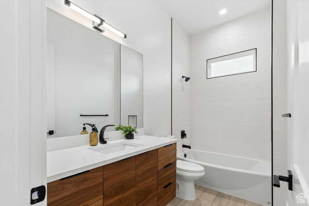 Bathroom with shower / bath combination, toilet, and vanity