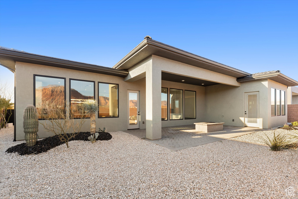 Back of house with a patio area and stucco siding