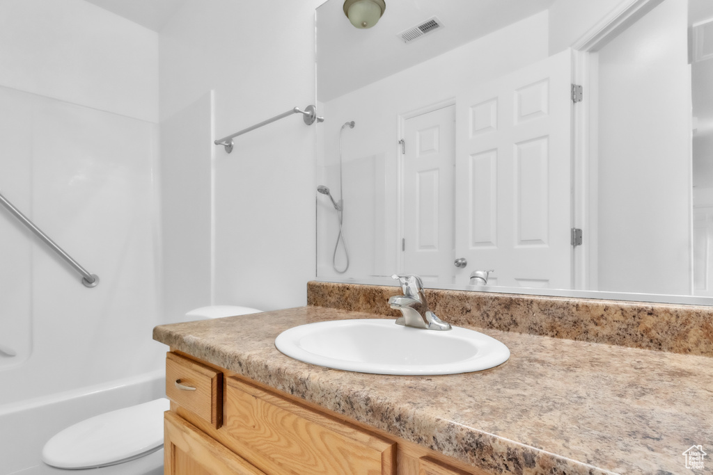 Bathroom with toilet, vanity, and shower / bath combination