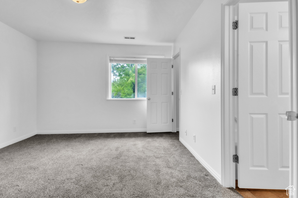 Empty room with carpet floors and baseboards