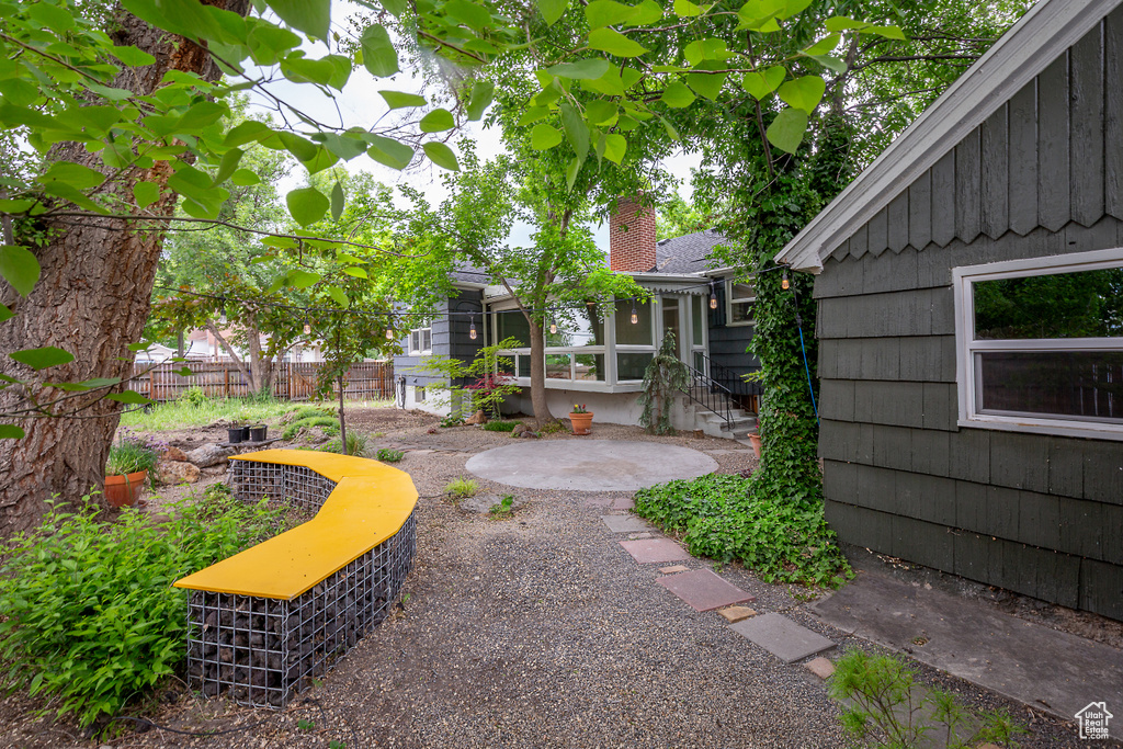 View of yard featuring fence and a patio