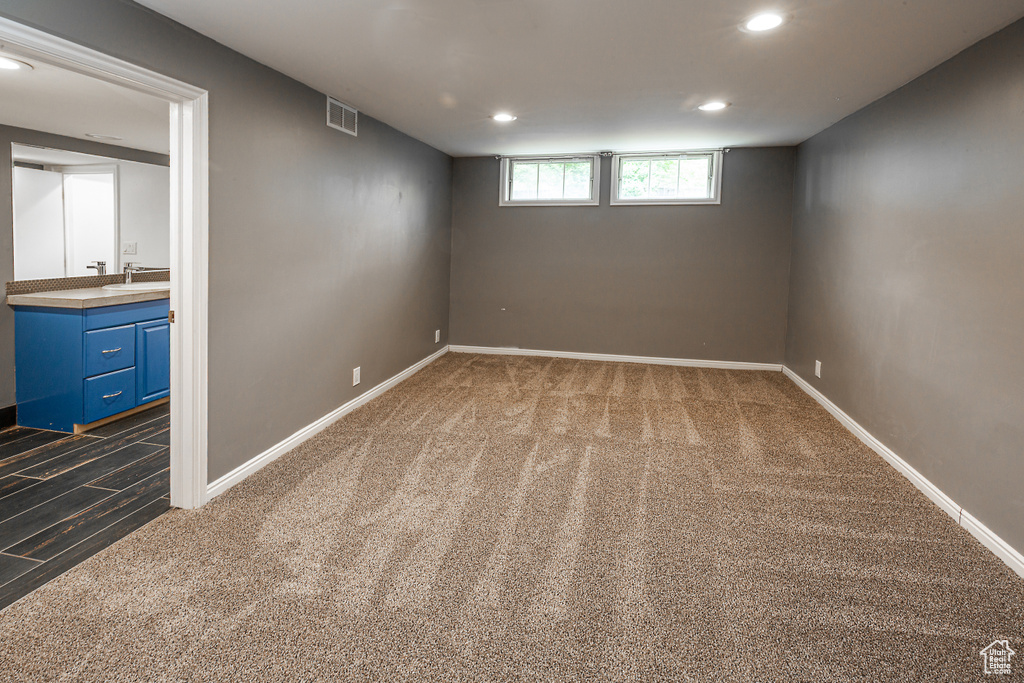 Basement featuring carpet floors, recessed lighting, baseboards, and a sink