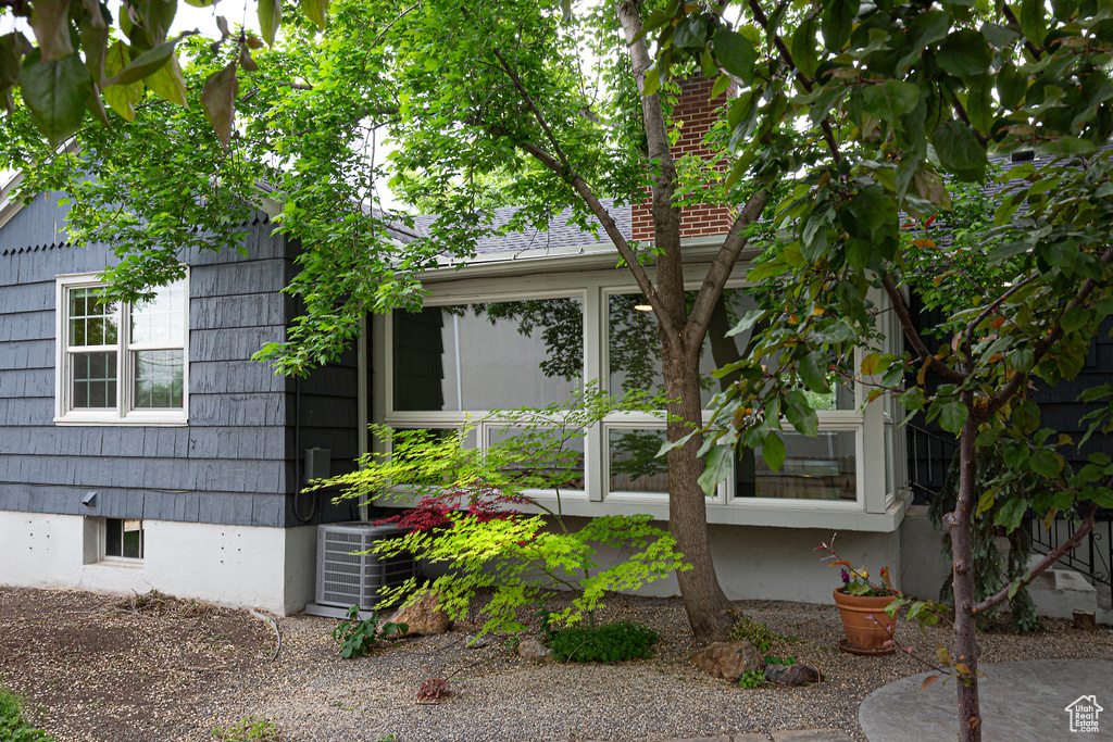 View of side of home featuring central air condition unit and a sunroom